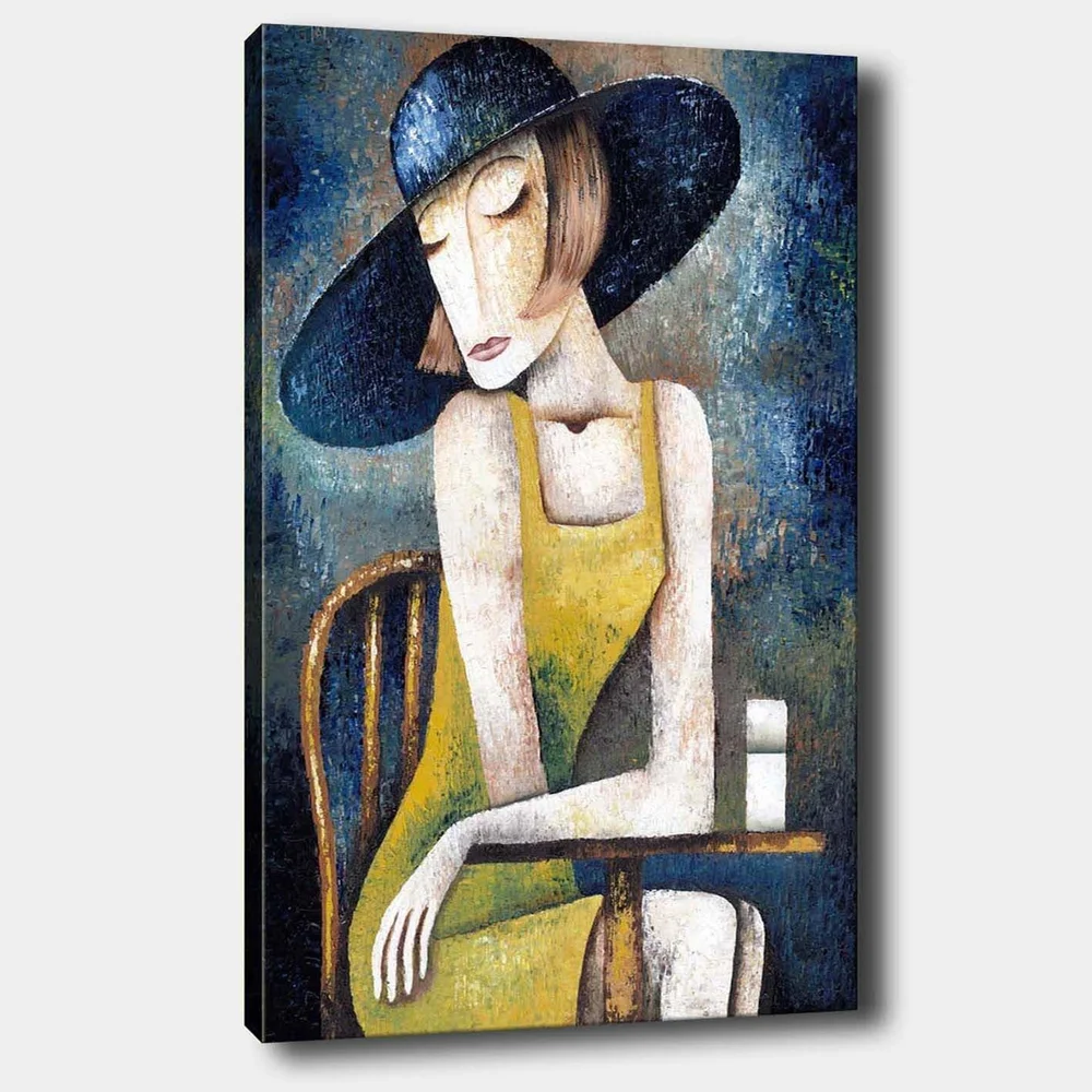 Lerretsbilde 70x100 cm - Kvinne i gul kjole sitter ved et bord med en hvit kopp, iført en stor svart hatt v:7330146